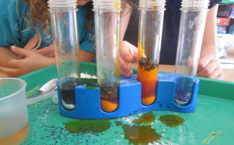 A group of children are playing with liquid in test tubes.