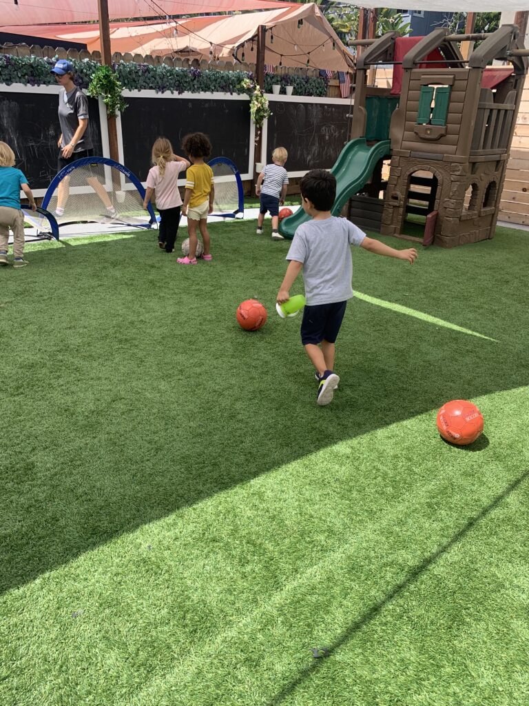 Kids playing soccer on a grassy field.