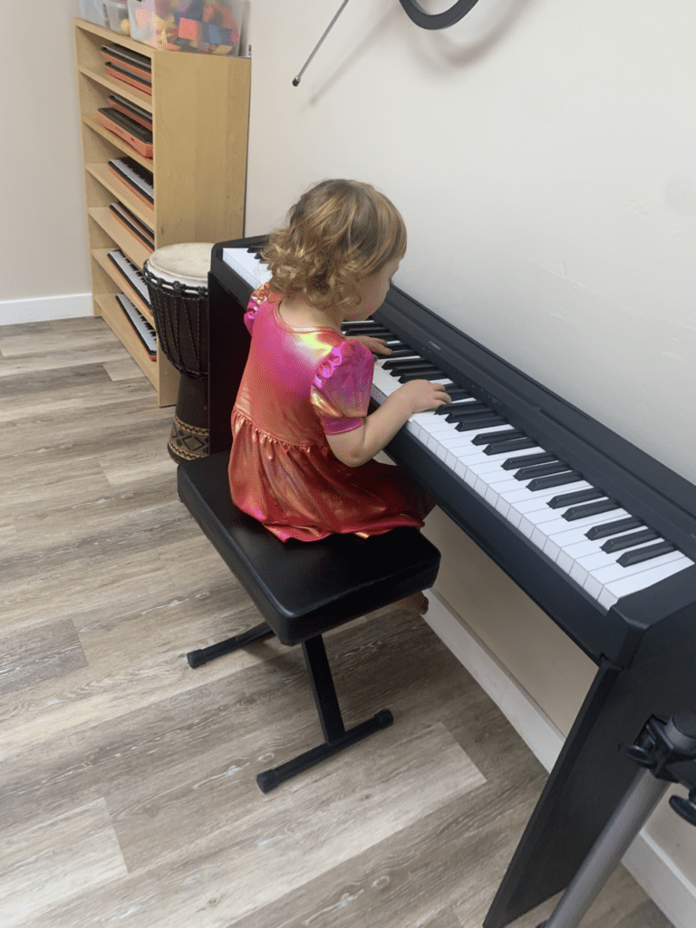 Young girl playing a digital piano.