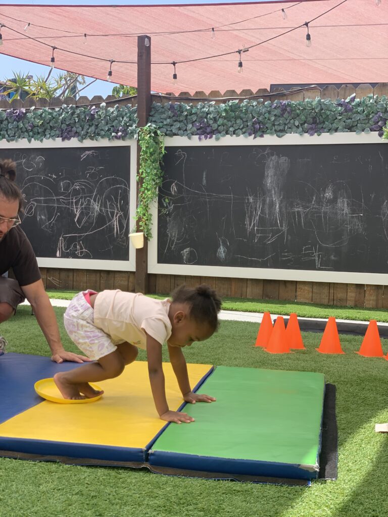 Young girl doing exercise on a mat.