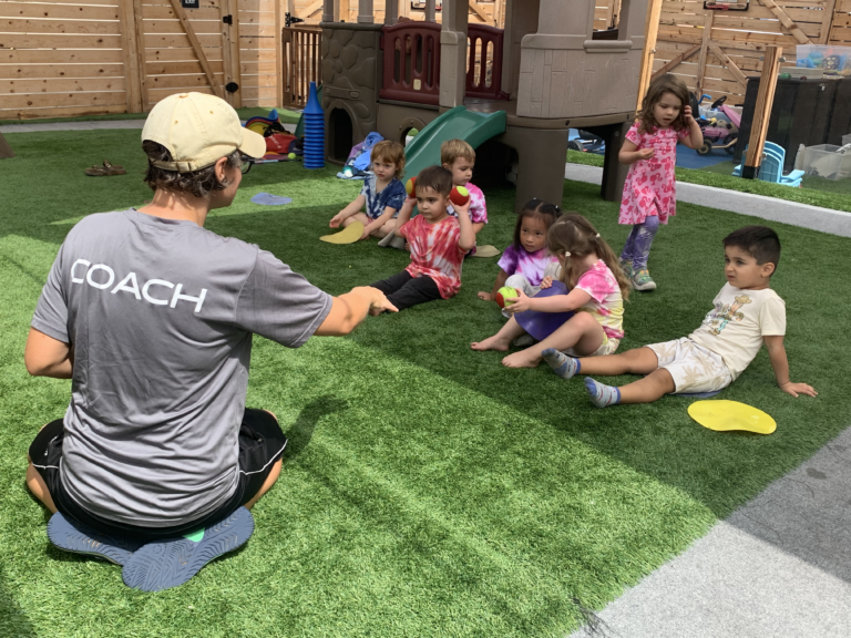 Coach working with kids on a playground.