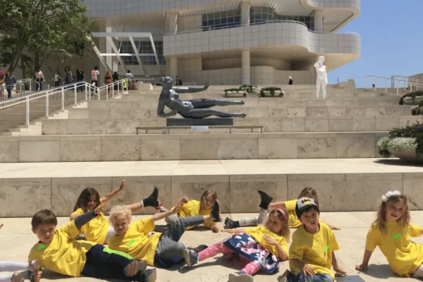 Children in yellow shirts enjoying a day outdoors at a modern architectural site.